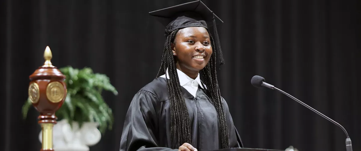 Student in cap and gown about to give a speech.