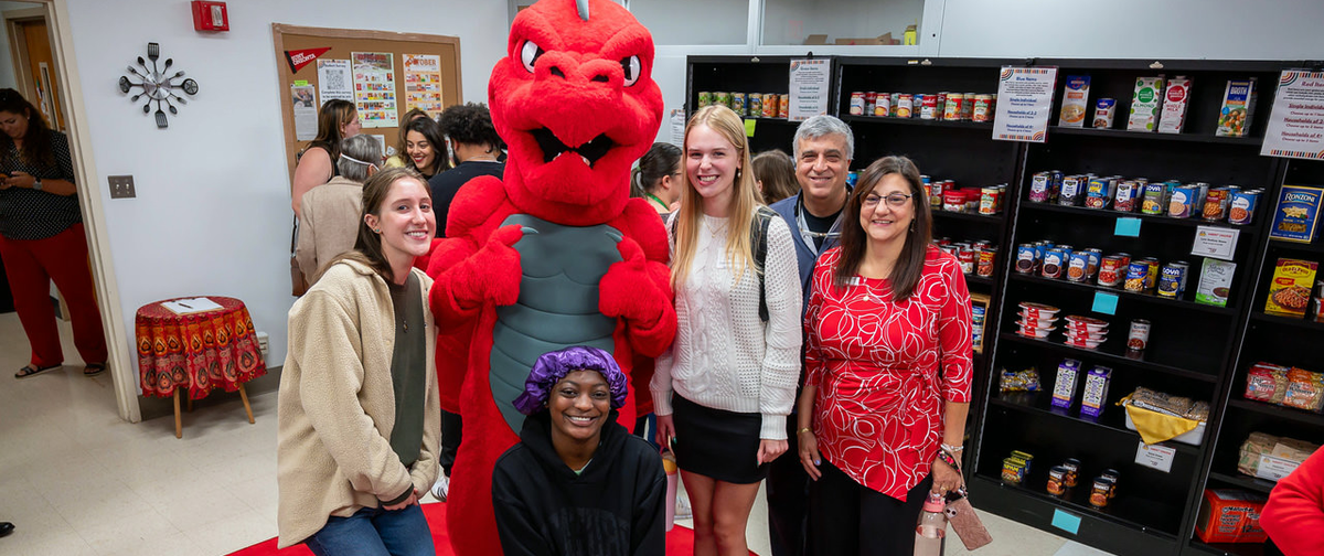 Red the Dragon with a group of students and staff at the food pantry