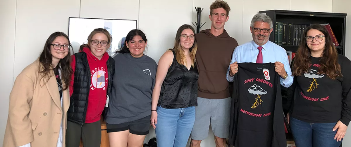 Meteorology Club presenting President Cardelle with t-shirt