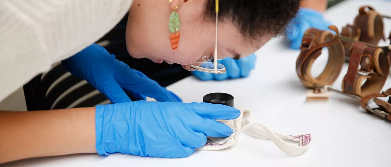 Museum Studies student examining an artifact.